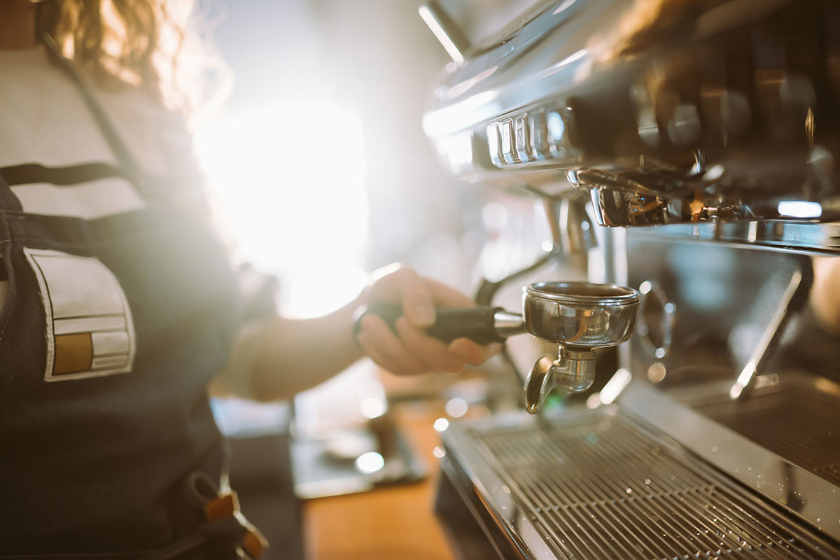 Barista setzt einen Siebträger an der Espressomaschine ein